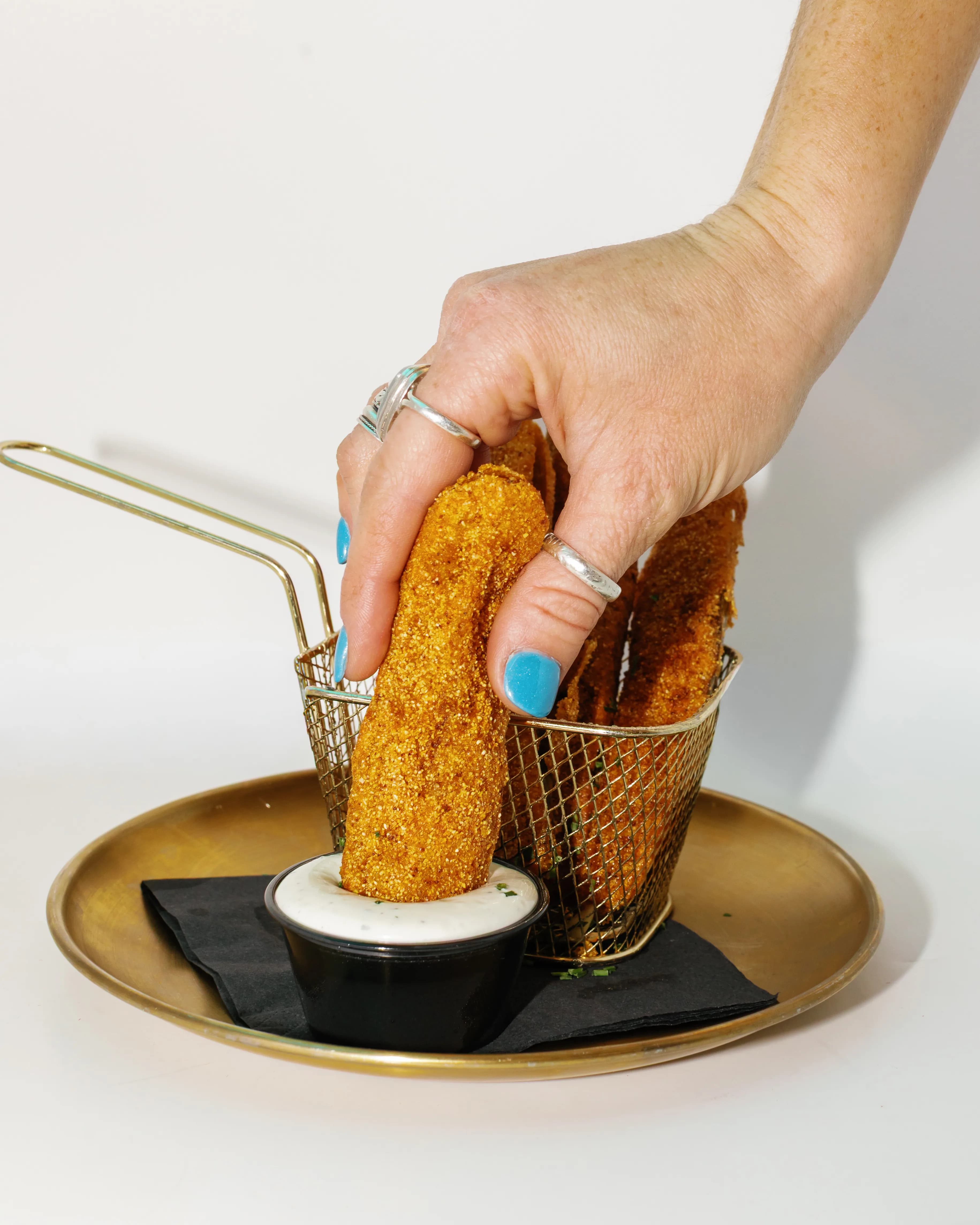 Basket of crispy fried pickle chips with house dipping sauce at Darling Aviary rooftop bar in Downtown Sacramento