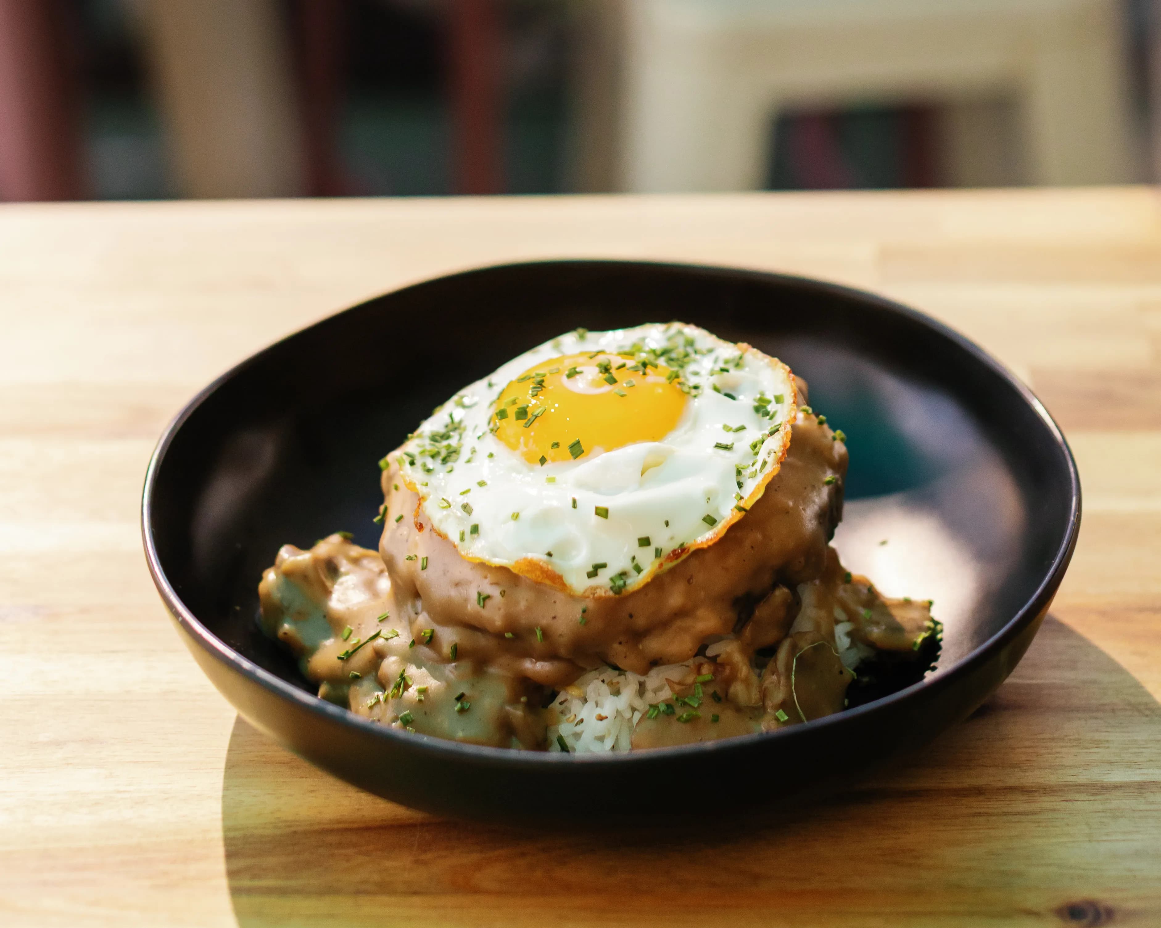 Loco Moco breakfast bowl with rice, beef patty, gravy and fried egg at Darling Aviary weekend rooftop brunch in Downtown Sacramento