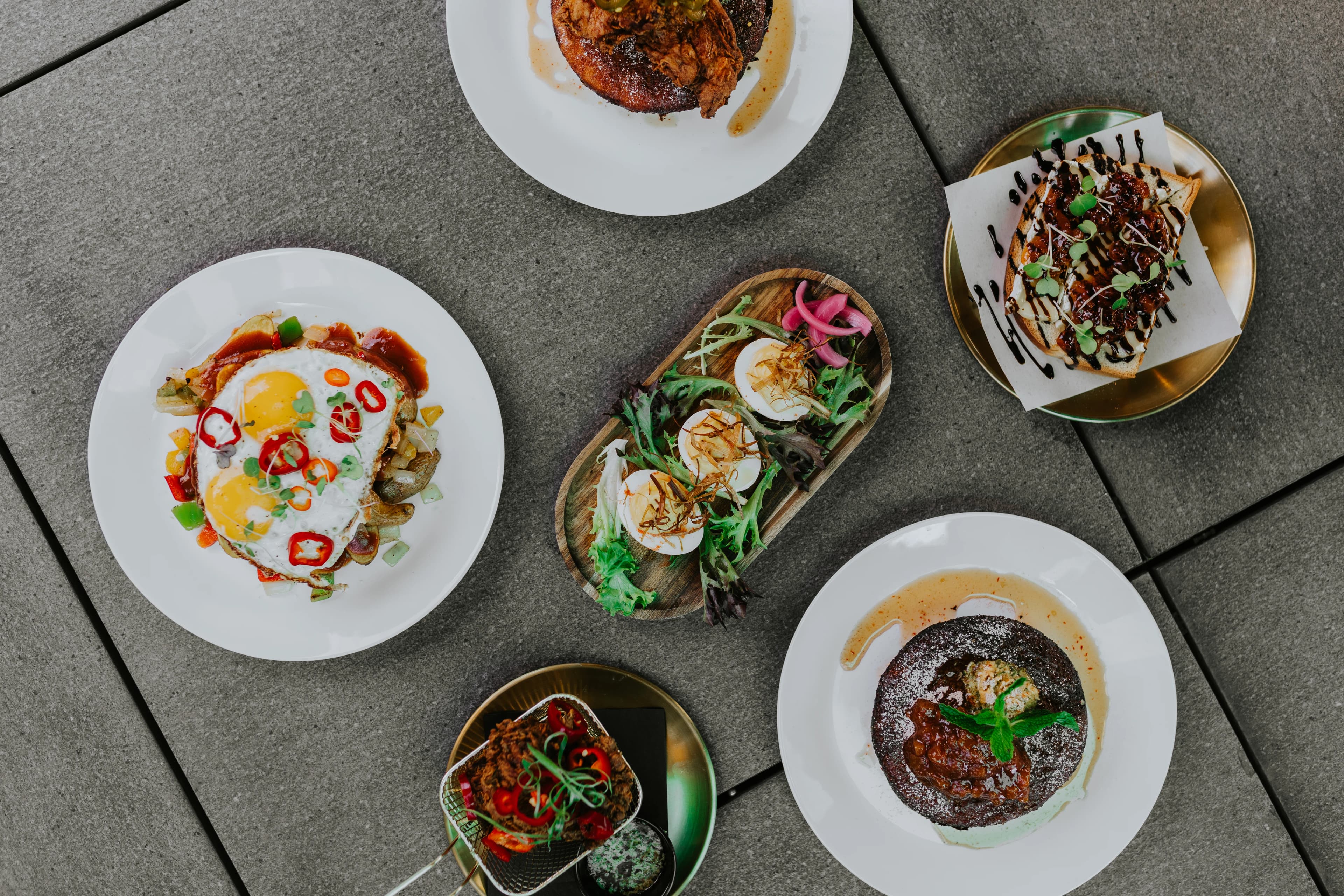 Spread of chef-driven brunch small plates on a table at Darling Aviary rooftop bar in Sacramento